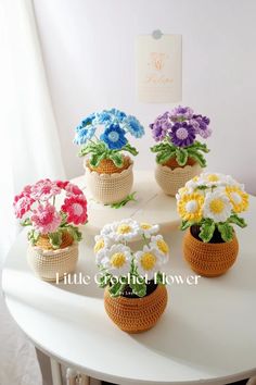 small crocheted flower pots sitting on top of a white table