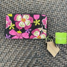 a small wallet sitting on top of a wicker table next to a green tag