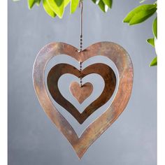 a metal heart hanging from a tree with two hearts in the shape of three interlocked hearts