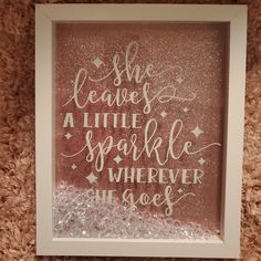 there is a pink and white frame with some writing on the inside of it that says she leaves a little sparkle wherever she goes