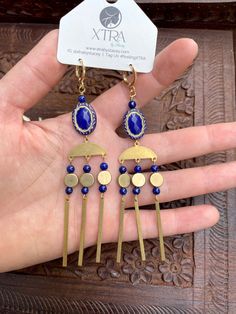 This listing is for long, dramatic, royal blue and gold chandelier earrings featuring vintage style etched beads, 4mm Lapis Lazuli stone beads, gold plated chain, and raw brass beads.Lapis Lazuli is known as the wisdom stone. It is thought to bring peace and harmony and encourage self-awareness and self-expression.These earrings hang approximately 4.0" inches from the lobe and measure about 0.75" inches across their widest point. The lever back closures are 22k gold plated and should be suitable Adjustable Dangle Jewelry With Gold Beads, Gold Artisan Beaded Earrings With Dangling Beads, Gold Bohemian Chandelier Earrings With Dangling Beads, Artisan Brass Jewelry With Round Beads, Bohemian Gold Beaded Chandelier Earrings, Bohemian Long Drop Blue Jewelry, Bohemian Blue Long Drop Jewelry, Artisan Blue Jewelry With Gold Beads, Bohemian Blue Earrings With Gold Beads