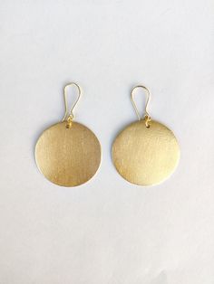 Here's the Mini version of our best-selling piece - Handmade Small African Disc Gold Earrings. The earrings are handmade and the round-shaped bold earrings are the most trending product of the season.  The earrings are the best choice for a chic look. Specifications: Brass Earrings Handmade Jewelry Gold Plated Round - Disc Shape Ear wire closure Bold Statement Jewelry Hypoallergenic Nickel & Lead-free Yellow Gold Circle Brass Earrings, Yellow Gold Circle Earrings In Brass, Hammered Round Wedding Earrings, Minimalist Round Brass Earrings, Gold Round Earrings With Ear Wire, Gold Circular Earrings For Wedding, Round Brass Earrings With Ear Wire, Matte Gold Brass Jewelry, Circular Brass Earrings With Ear Wire