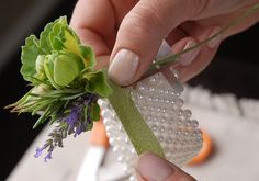 a person is holding a flower and cutting it into small pieces on a cake platter