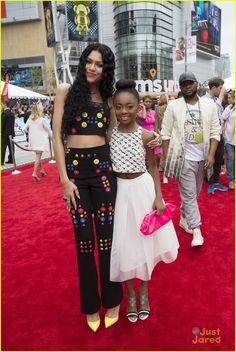 two women standing next to each other on a red carpet