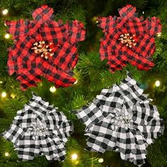 three red and black plaid poinsettias hanging from a christmas tree