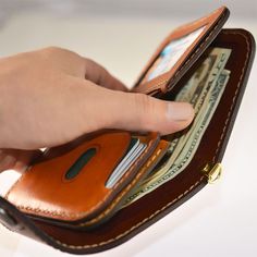 a person is taking money out of a wallet