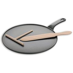 two wooden utensils sitting on top of a frying pan