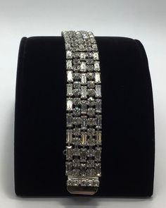 "- Silver tone Metal, Clear Rhinestones - A very desirable bracelet! You'll fall in love with this silver tone rhodium plated wide clear rhinestone bracelet. Loaded with 3 rows of clear baguette cut rhinestones intermixed with 2 rows of clear round rhinestones. The clasp is even sprinkled with rhinestones. A jaw dropping piece! You'll light up a room for sure when you wear it. It measures 7.5\" long and .75\" wide. It is missing its safety chain. This is the type of bracelet that once you try it Safety Chain, Rhinestone Bracelet, Baguette Cut, Clear Rhinestones, Chain Link Bracelet, Vintage Silver, Rhodium Plated, Chain Link, Silver Tone