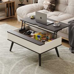 a coffee table with an open drawer underneath it on top of a rug in front of a couch