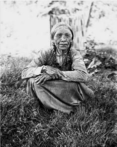 an old woman is sitting in the grass