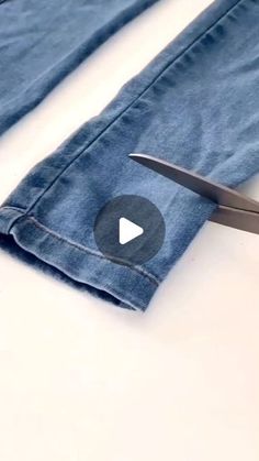 a pair of scissors cutting through some blue jeans