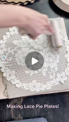 a person is making lace pie plates on a table