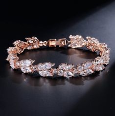 A classy bracelet for the modern bride! Featuring faceted cubic zirconia that catch the light from every angle, the bracelet is rhodium / 14K rose gold / 14K yellow gold plated for a flawless finish which perfectly enhances the intricate detailing and conveys a modern take on old elegance. The bracelet measures 0.5" wide (approx. 15mm) and 7" long (approx. 18cm). Closure is a secure fold-over clasp. Choose between Silver, Rose Gold and Yellow Gold finishes. To make your choice, select from the d Trollbeads Bracelet, Bridal Earrings Studs, Crystal Earrings Wedding, Bridal Earrings Drop, Cz Bracelet, Bride Earrings, Crystal Bangle, Leaf Jewelry, Bridal Bracelet