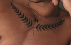 a man has a fern tattoo on his chest