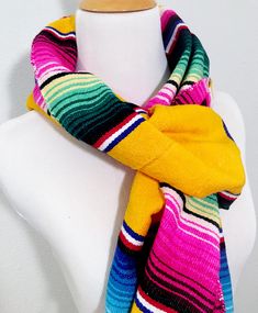 I've turned a traditional Mexican serape into a warm, comfy Mexican scarf. Made from an authentic Mexican serape, each scarf wrap is 78 inches long and 9 inches wide. Each end is finished with 3.5 inch long fringe. It can be wrapped around your neck several times for added warmth. It can be draped across your shoulders, tied at your throat or held in place with a simple knot. I finished off the edges with a coordinating thread in a zigzag pattern. Bohemian Multicolor One Size Wraps, Bohemian Multicolor One-size Wraps, Hippie Multicolor Scarf One Size, Multicolor Bohemian Poncho With Scarf, Yellow Bohemian Scarves For Festivals, Bohemian Multicolor Poncho With Scarf, Yellow Bohemian Scarves One Size, Multicolor Hippie Shawl One Size, Traditional Multicolor Scarves For Winter