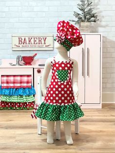 the doll is wearing a red and green polka dot dress