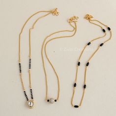 I am offering three handmade mangalsutra which is perfect for daily use. It will go with any type of costume.  Indian traditional kundan mangalsutra studded with withe stones. Simple yet elegant design with just black beads.  Third one is small American diamond stones studded bead as pendant. All three mangalsutra has 22K gold plating.   Gift your family & friends with this Mangalsutra Modern design. Three beautiful handmade mangalsutra. I keep length 17 inches as it can be seen close to neck. O Daily Wear Mangalsutra Designs, Chain Mangalsutra Designs, Mangalasutram Chain Designs, Gold Chain With Black Beads, Modern Mangalsutra Designs Gold, Daily Wear Gold Mangalsutra Designs, Daily Wear Mangalsutra, Chain With Black Beads, Modern Mangalsutra Designs