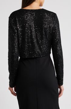 Sequins sparkle under the lights on a long-sleeve bolero that will add old Hollywood glamour to your evening look. Front hook-and-eye closures V-neck Long sleeves 95% polyester, 5% spandex Hand wash, line dry Imported Fitted Evening Shrug For Fall, Formal Long Sleeve Shrug For Fall, Fitted Long Sleeve Shrug For Evening, Elegant Winter Shrug For Night Out, Evening Long Sleeve Shrug For Fall, Elegant Party Shrug For Fall, Elegant Fall Party Shrug, Chic Long Sleeve Formal Shrug, Black Evening Shrug For Winter