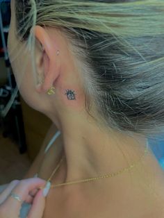 a woman with a small pineapple tattoo behind her ear