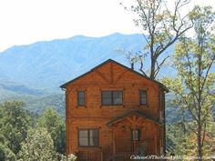 a large wooden house sitting on top of a lush green hillside