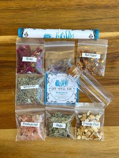 six clear bags filled with different types of spices and herbs on top of a wooden table