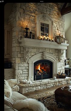 a living room with a fire place in the middle and candles on the mantle above it