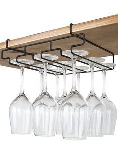 four wine glasses are hanging from a shelf