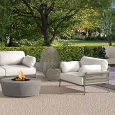 an outdoor living room with white furniture and a fire pit