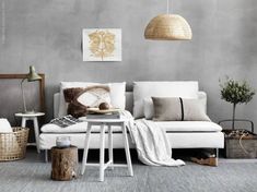 a living room with grey walls and white furniture in the corner, including a couch