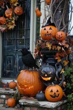 pumpkins and other halloween decorations on the steps in front of a house