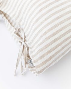 a white and gray striped pillow on a white surface