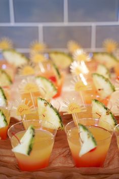 small cups filled with fruit and garnish on top of a wooden platter