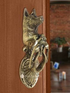 a door handle with a dog head on it and an elephant's tail hanging from the side