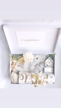 the congratulations gift box is filled with white flowers and personalized gifts for brides