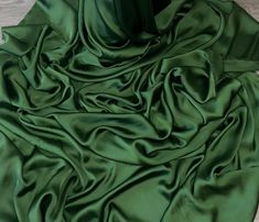 a green cloth laying on top of a wooden floor