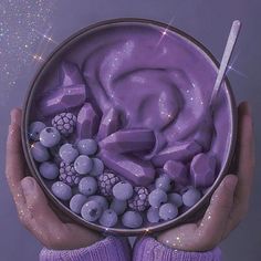 a person holding a bowl filled with blueberries and marshmallows