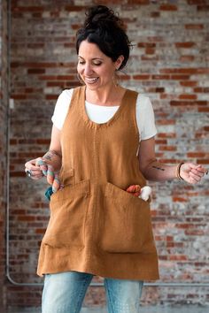 a woman in an apron is smiling and holding something