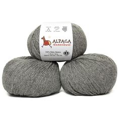 three skeins of alpaca yarn in grey