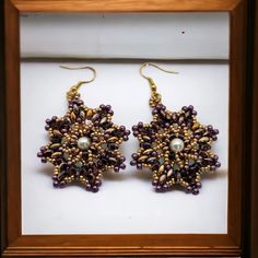 1. Introducing our exquisite product, a stunning piece of jewelry featuring a 4mm pearl round bead, purple/gold super duo beads, 11/0 purple seed beads, and 15/0 gold seed beads.  2. Crafted with care, this hypoallergenic hook ensures comfort and safety for all-day wear.  3. The nylon 6 lb thread used in its construction guarantees durability and longevity.  4. With a length of 2.5 inches (from hook) and a width of 1.5 inches, this elegant accessory is the perfect size to make a statement.  5. W Gift Gold Beaded Earrings, Gold Beaded Earrings With Bead Caps As Gift, Gold Beaded Earrings With Bead Caps For Gift, Handmade Gold Pearl Beaded Earrings, Gold Earrings With Spacer And Round Beads, Handmade Gold Pearl Earrings With Round Beads, Colorful Beads Pearl Earrings, Handmade Gold Pearl Earrings, Pearl Earrings With Gold Beads For Gift