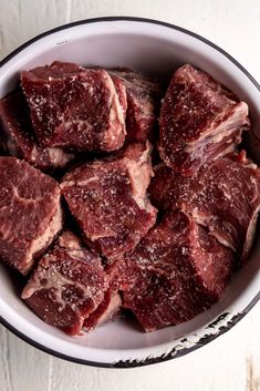 a bowl filled with raw meat sitting on top of a table