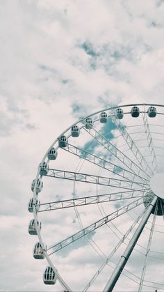 a ferris wheel with clouds in the background