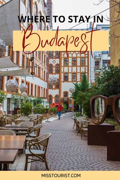 a street with tables, chairs and umbrellas in front of the words where to stay in budapest