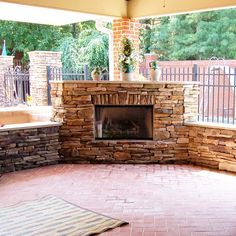 an outdoor fireplace in the middle of a patio