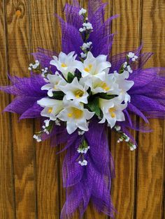 a purple and white flower bouquet on a wooden fence with flowers in the center, along with baby's breath