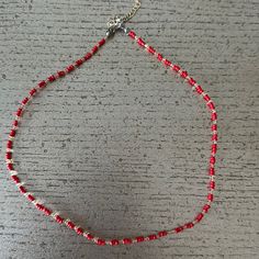 a red and white beaded necklace on a table