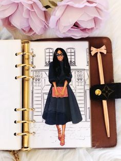 an open notebook with a drawing of a woman in a black dress and pink flowers