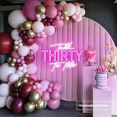 there is a pink and gold balloon arch with the words thirty to me on it