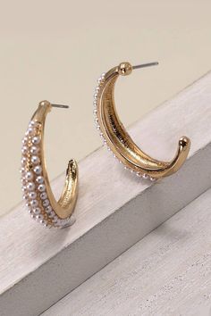 These earrings feature sleek hoop designs adorned with lustrous pearls, adding a touch of sophistication to any ensemble. Crafted with meticulous attention to detail, the combination of pearls and hoops creates a luxurious and versatile accessory. Product Details: length: 1.75" width: 1" Baseball Hat Hairstyles, Greeting Card Collection, Belt Jewelry, Wall Accessories, Pearl Hoop Earrings, Earring Sale, Pearl Studs, Hat Hairstyles, Handbag Accessories