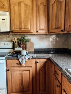 a kitchen with wooden cabinets and granite counter tops, including a dishwasher on the stove