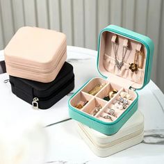 two small jewelry boxes sitting on top of a table next to each other with necklaces in them